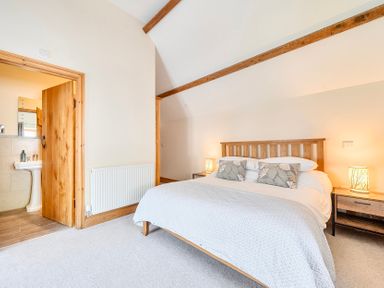 A bedroom with a bed and ensuite bathroom view at The Barn in Corwen