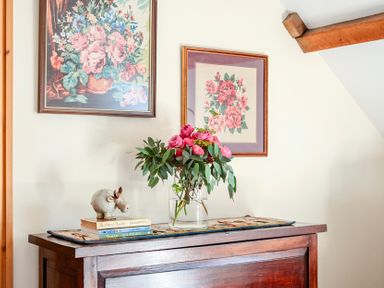 A table with flowers and books at The Barn in Corwen