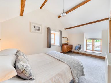 A bedroom with a bed and a window at The Barn in Corwen