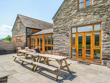 An outdoor patio with a table and chairs at The Barn in Corwen