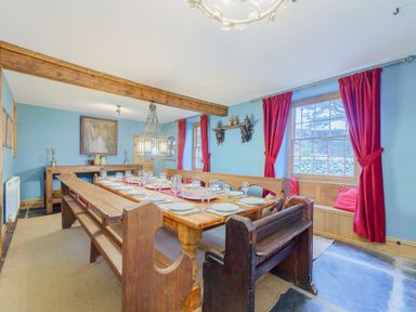 A dining room with wooden benches and a table set with plates and glasses at The Druids in Druid near Corwen