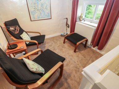 A snug with armchairs and footstools at The LA'AL Cragg in Kirkby Stephen