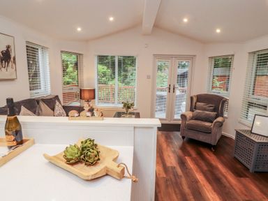 A living room with a cutting board and plants at Willows Lodge, White Cross Bay, near Windermere