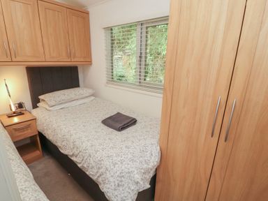 A bedroom with a single bed and a wardrobe at Willows Lodge, White Cross Bay, near Windermere