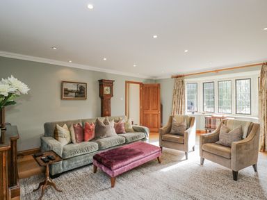 A living room with a sofa and armchairs at The Old Hall in Tetbury
