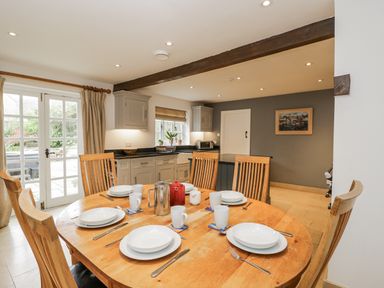 A kitchen with a wooden table and chairs at The Old Hall in Tetbury