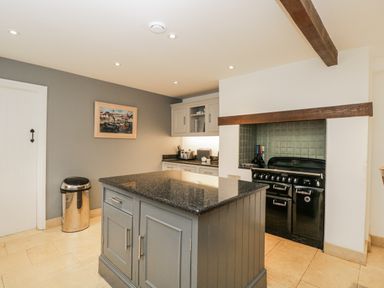 A kitchen with an island and stove at The Old Hall in Tetbury
