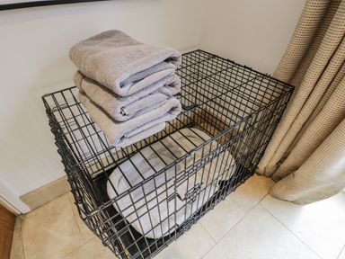 A dog crate with towels and a bed at The Old Hall in Tetbury