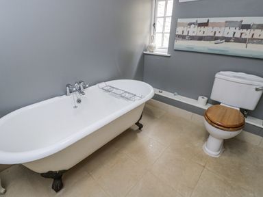 A bathroom with a bathtub and toilet at The Old Hall in Tetbury
