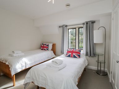 A bedroom with two beds and a window at The Old Hall in Tetbury