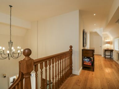 A hallway with a staircase and light fixtures at The Old Hall in Tetbury