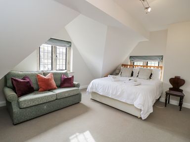 A bedroom with a bed and a sofa at The Old Hall in Tetbury