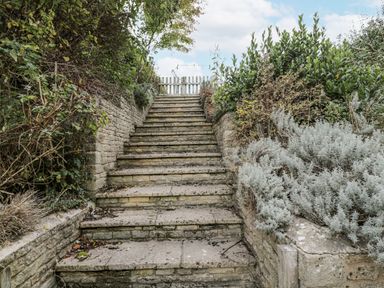 A pathway leading up stone stairs with greenery at The Old Hall in Tetbury