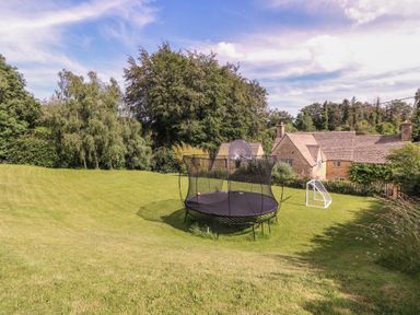 An outdoor area with a trampoline and soccer goal at The Old Hall Westonbit Nr Tetbury
