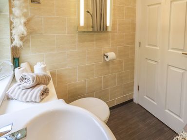 A bathroom with a sink towels toilet paper and a toilet at Our Happy Place Lakeside 16 Borwick near Carnforth