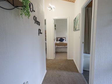 A hallway with carpet leading to a bedroom and bathroom at Our Happy Place Lakeside 16 Borwick near Carnforth