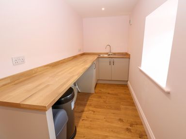 A kitchen with wooden countertops a sink cabinets and a window at The Coach House in Great Whittington near Corbridge