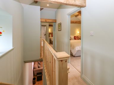 A hallway with wooden railing and doors leading to bedrooms at The Coach House in Great Whittington near Corbridge