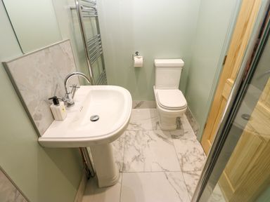 A bathroom with a white sink toilet and towel rack at The Coach House in Great Whittington near Corbridge