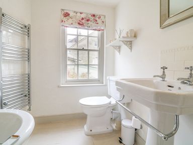 A bathroom with a toilet sink mirror heated towel rail and window at Aunt Dora's in Port Isaac