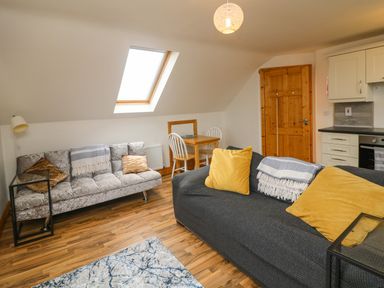 A living room with two sofas and a small dining table under a skylight window at Old Field Hideaway Slade near Fethard-On-Sea County Wexford