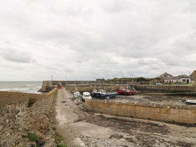 A harbor with boats docked near stone walls and buildings at Old Field Hideaway Slade near Fethard-On-Sea County Wexford