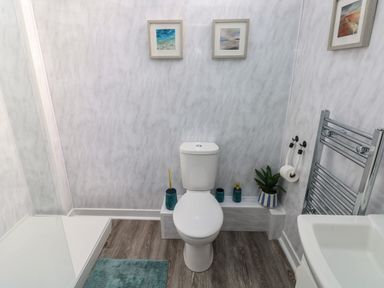 A bathroom with a toilet a shower a sink and a towel rack at Tower Cottage Near Pembroke