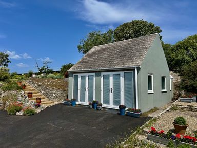 A house with doors and windows surrounded by garden at Tower Cottage Near Pembroke