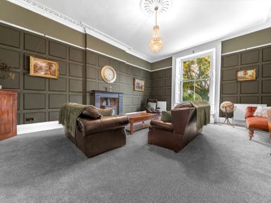 A sitting room with leather sofas a wooden coffee table a globe and large window at 8 Corkickle in Whitehaven