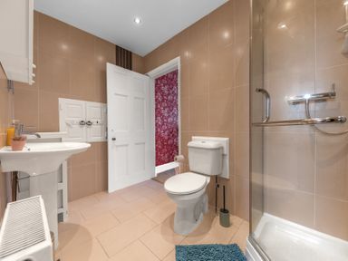 A bathroom with a toilet sink shower and radiator at 8 Corkickle in Whitehaven