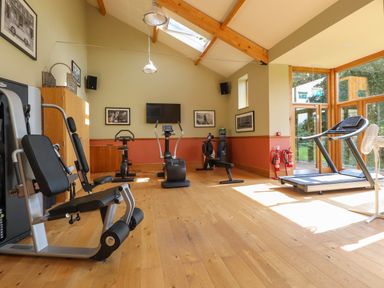 A gym room with exercise machines a treadmill and a stationary bike at 7 The Oaks in Long Preston near Hellifield