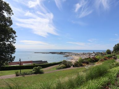 A coastal view with a beach a harbor and grassy park area at Sir George Baker Cabin in Uplyme