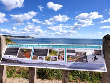 An informational sign about the Jurassic Coast World Heritage Site overlooking the coastline and sea at Sir George Baker Cabin in Uplyme
