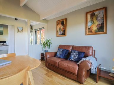 A living room with a sofa and table at Sir George Baker Cabin in Uplyme