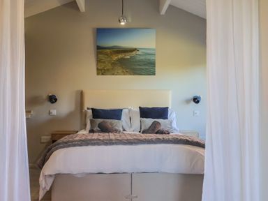 A bedroom with a bed and painting at Sir George Baker Cabin Uplyme