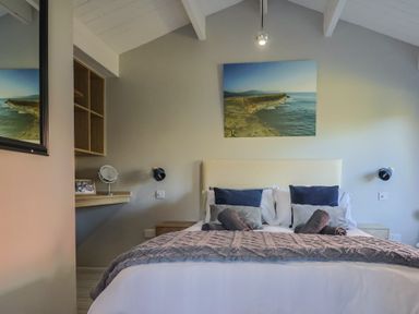 A bedroom with a bed and desk at Sir George Baker Cabin in Uplyme