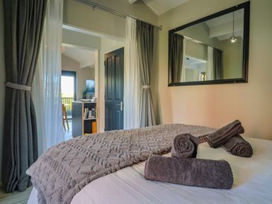A bedroom with a bed and towels at Sir George Baker Cabin, Uplyme