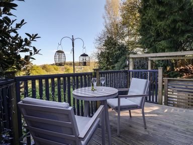 A table and chairs on a deck with a view at Sir George Baker Cabin in Uplyme