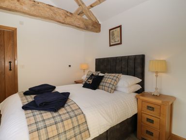 A bedroom with a double bed bedside tables and lamps at Keepers Barn in Bromyard