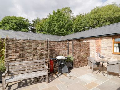 A garden area with patio furniture and a barbecue grill at Keepers Barn Bromyard