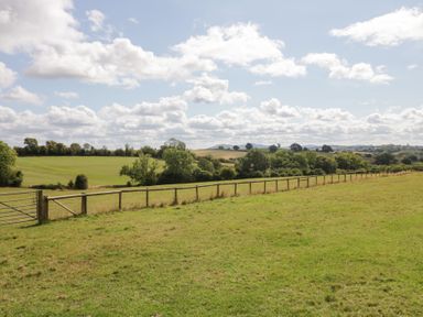 A field with a fence and gate at Keepers Barn in Bromyard