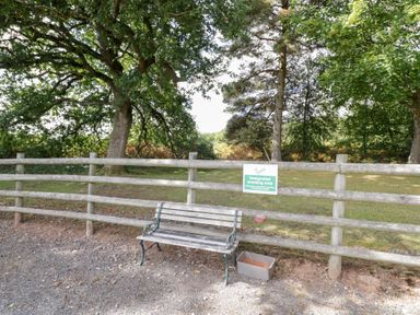 An outdoor area with a bench and a designated smoking area sign at Keepers Barn in Bromyard
