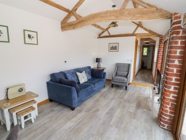 A living room with a sofa and an armchair at The Cow Shed in Bromyard