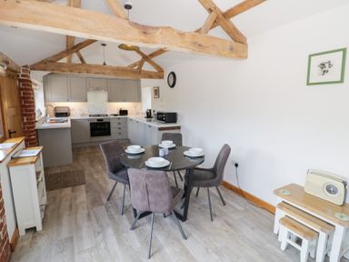 A kitchen with a dining table and chairs at The Cow Shed in Bromyard