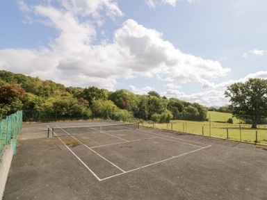 A tennis court surrounded by greenery at The Cow Shed in Bromyard