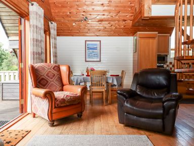 A living room with two armchairs and a dining table with chairs at Trout River Retreat Clifford Bridge near Moretonhampstead