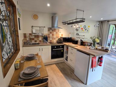 A kitchen with countertops, appliances, and dining area at Ty Barddu, Cwmorgan near Newcastle Emlyn