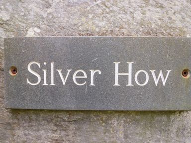 A stone nameplate engraved with Silver How mounted on a rough stone wall