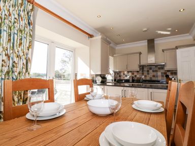 A kitchen with wooden dining table set with white dishes and glasses at Silver How in Ambleside