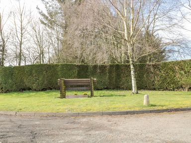 A grassy area with a wooden sign reading Fram Park next to a tree and hedge in the background at Matfen in Longframlington